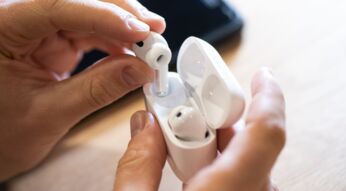 Ein Mann zieht AirPods Pro von Apple aus dem Ladecase.