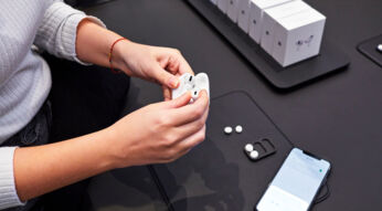 Frau hält AirPods Pro im Ladecase in der Hand