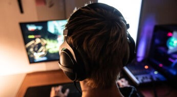 Mann mit Kopfhörern beim Gaming am Computer