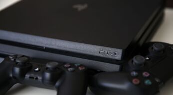 Die PS4 und zwei Controller liegen auf einem Tisch.
