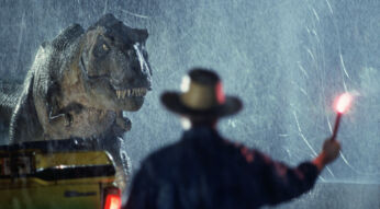 Dr. Alan Grant (Sam Neill) schwingt eine Leuchtfackel, um den T. Rex abzulenken im Film Jurassic Park
