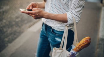 Frau mit Einkaufstasche erledigt Einkäufe mit smarten Einkaufslisten