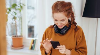 Frau schaut Instagram-Stories am Handy an.