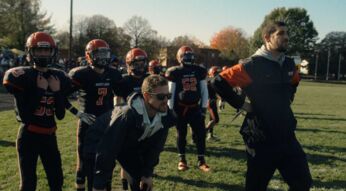 Zwei Trainer am Rand eines Football-Felds bei einem Spiel