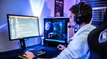 Ein Mann sitzt am Computer und chattet über Discord.