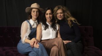 Drei Frauen vor dunklem Hintergrund