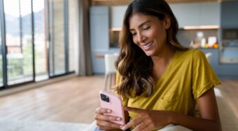 Junge Frau schaut auf ihr iPhone.