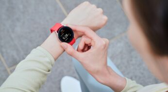 Frau drückt Knöpfe der Galaxy Watch4 am linken Handgelenk