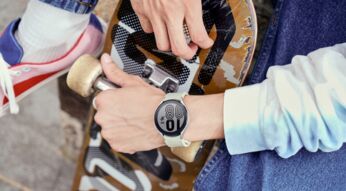 Hand mit Galaxy Watch4 hält Skateboard