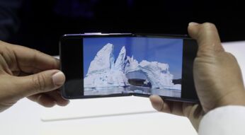 Zwei Hände halten das in der Mitte geklappte Smartphone Galaxy Z Flip