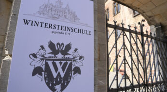 Filmkulisse: Schild an einem Schloss mit der Inschrift "Wintersteinschule"