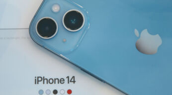 iPhone 14 in Blau auf einem beigen Tisch