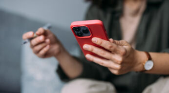 Mensch hält iPhone mit roter Hülle