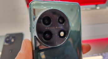 Hand hält das Smartphone OnePlus 11 in einem Handy-Geschäft