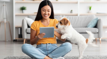 Frau spielt mit ihrem Hund via App