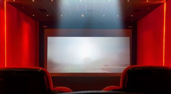 Roter Kinosaal mit Sessel und Leinwand