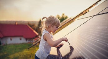 Ein Mädchen schaut sich eine Solarzelle von Nah an