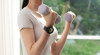 Frau mit Hanteln und Smartwatch