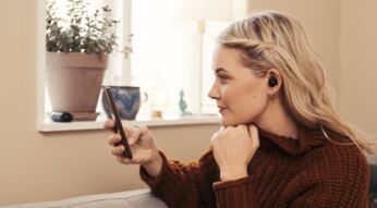 Frau trägt schwarze In-Ear-Kopfhörer