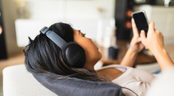 Juinge Frau mit Kopfhörer und Smartphone