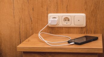 Ein Handy lädt an der Steckdose auf.