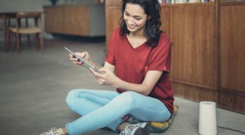 Junge Frau sitzt entspannt auf dem Boden neben dem GigaCube