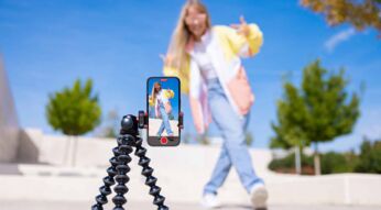 Ein Teenagermädchen filmt sich selbst mit einem Handy auf einem Stativ