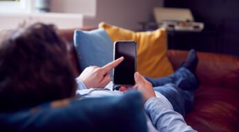 Mann tippt auf ein Smartphone-Display.