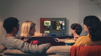 Freunde sitzen zusammen auf dem Sofa und schauen Vodafone GigaTV