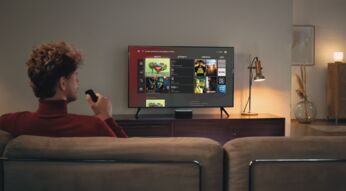 Mann mit Fernbedienung schaut GigaTV