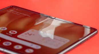Smartphone Google Pixel Fold aufgefaltet auf rotem Untergrund liegend