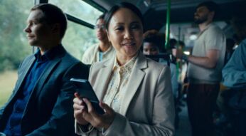 Frau sitzt mit Handy im Bus