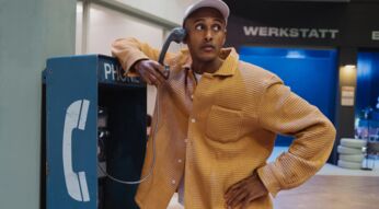 Teddy Teclebrhan steht an einer Telefonzelle