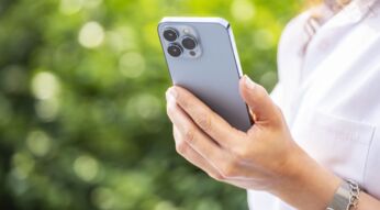 Frau schaut sich ein Kontaktposter auf dem iPhone an.