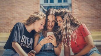 Mädchen schauen sich gemeinsam TechHacks auf dem Handy an