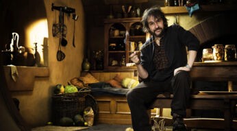 Peter Jackson sitzt auf einer Holzbank an seinem Set von Der Hobbit