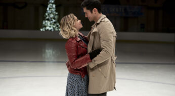 Tom und Katarina umarmen sich beim Schlittschuhlaufen auf der Eisfläche uns schauen sich tief in die Augen