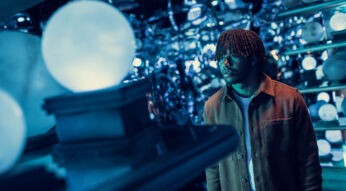 Ein junger Mann schaut auf eine Glaskugel in der Hallo der Prophezeigungen