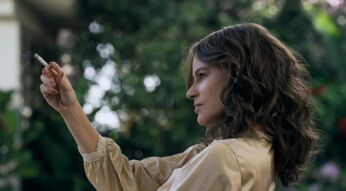 Eine Frau hält eine Zigarette hoch.