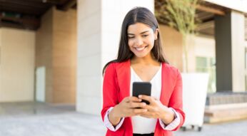 Frau schaut lächelnd auf ihr Android-Smartphone