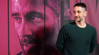 Ein Man vor einem Riesenplakat