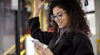 Frau schaut im Bus auf ihr Smartphone