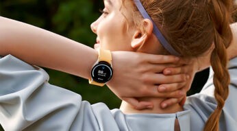 Junge Frau in Sportbekleidung mit Smartwatch von Samsung.