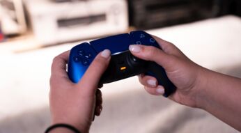 Frau hält PS5-Controller in der Hand