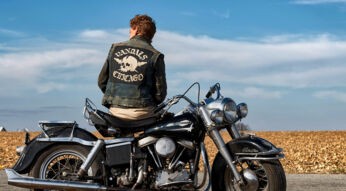 Ein Biker von hinten gesehen, der quer auf seinem Motorrad sitzt.