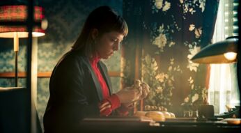 Eine junge Frau sitzt am Schreibtisch.