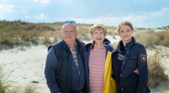 Die "SOKO Wismar"-Darsteller:innen Udo Kroschwald, Katharina Blaschke und Hanna Plaß vor einer Dünen-Kulisse