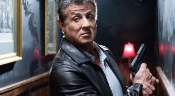 Sylvester Stallone hält eine Pistole in der Hand.