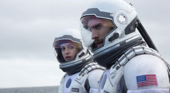 Auf diesem Bild zu Interstellar Fakten sind die Charaktere Amelia Brand und Cooper in ihren Raumanzügen zu sehen, gespielt von Anne Hathaway und Matthew McConaughey. Beide blicken konzentriert in die Ferne, während Regentropfen auf ihren Helmen zu sehen sind. Die Szene wirkt angespannt und ernst, passend zur Atmosphäre des Films, der Themen wie Raumfahrt und Überlebenskampf behandelt.
