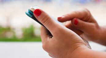 Frau tippt auf das Display ihres Smartphones.